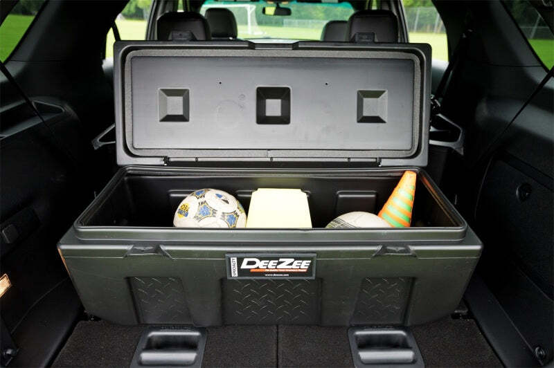 Dee Zee storage box installed in the back of an SUV, holding various sports equipment, highlighting its spacious design and utility for keeping items organized and secure during transport.